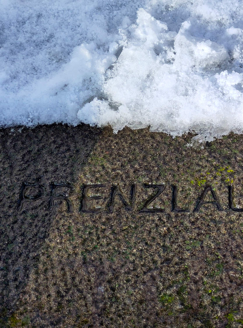 A stone with Prenzlauerberg carved on it in the snow